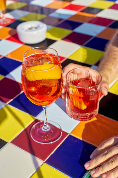 Spritz cocktail and Negroni on colorful tiled table