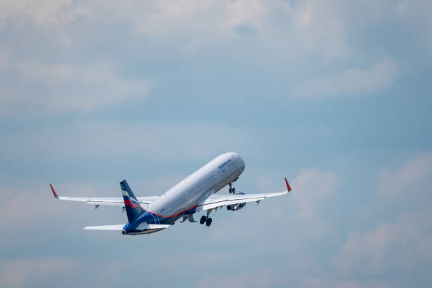 avion d'entreprise de compagnies aériennes d'aeroflot volant dans le ciel nuageux - aeroflot photos et images de collection