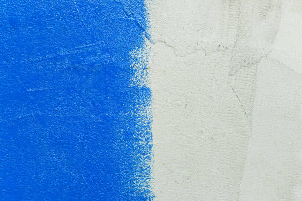 istock texture of a gray rough wall that is half painted with bright blue paint 1177719717