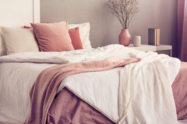 istock King size bed with pastel pink and white bedding in trendy bedroom interior 1177720290