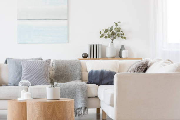 istock Pastel blue and white abstract oil painting on empty white wall with console table with flowers in vase and books 1177720754
