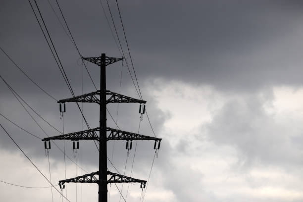 High voltage tower silhouette with electrical wires on storm sky background with dark clouds Electricity transmission lines, power supply concept blackout photos stock pictures, royalty-free photos & images