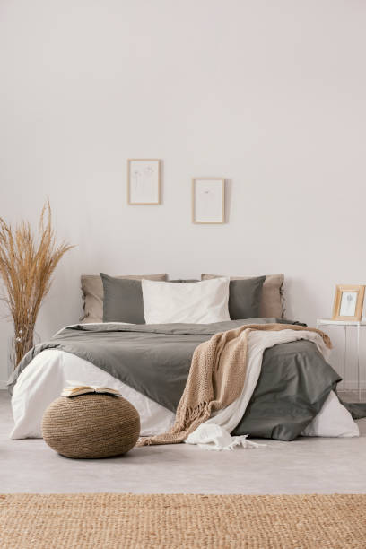 istock White and beige blankets on grey duvet on comfortable bed in bright bedroom interior 1177724586