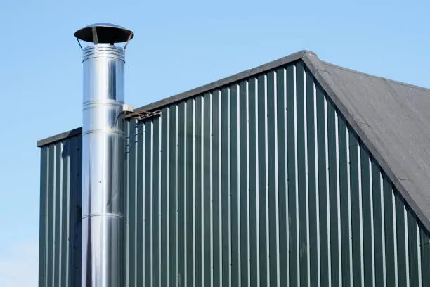 Flue chimney fixed to building exterior wall stainless steel from exhaust boiler plant room uk