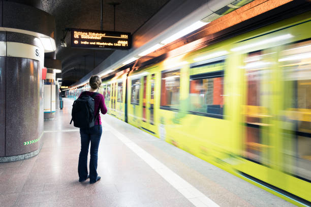 istock Young woman waiting at platform, while subway drives by 1177729801