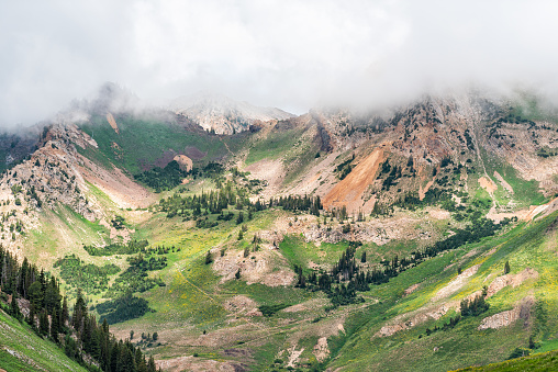 Albion Basin, Utah summer cloudy morning in 2019 with clouds on stormy day and mist fog covering blanketing rocky Wasatch mountains