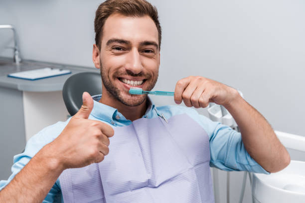 istock handsome bearded man showing thumb up while holding toothbrush 1177732257
