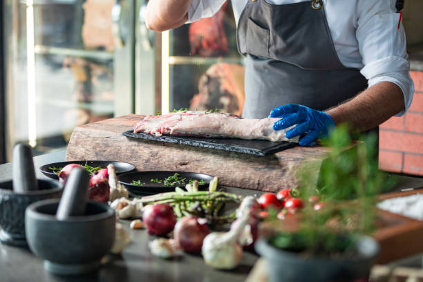 istock Chief marinating, spicing and seasoning meats in kitchen 1177734396