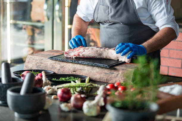 istock Chief marinating, spicing and seasoning meats in kitchen 1177734873