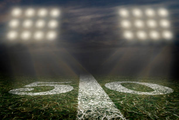 american football field 50 yard line friday night lights - bola imagens e fotografias de stock