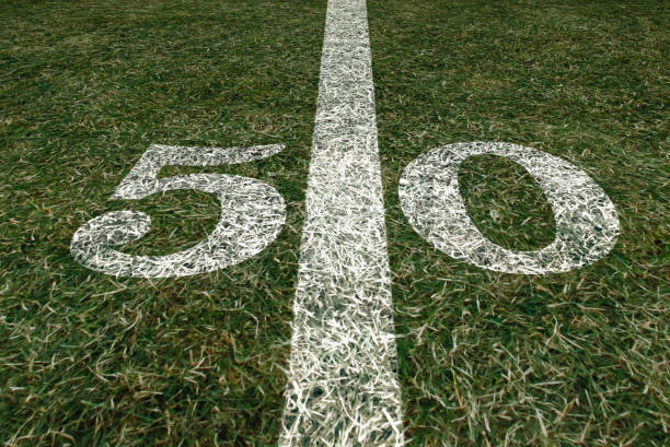 american football field 50 yard score line. team sports. fifty yard line. - teamsport imagens e fotografias de stock