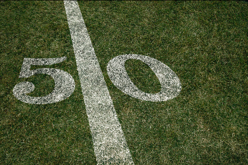 American Football field 50 yard score line. Team sports. Fifty yard line during Friday night lights.
