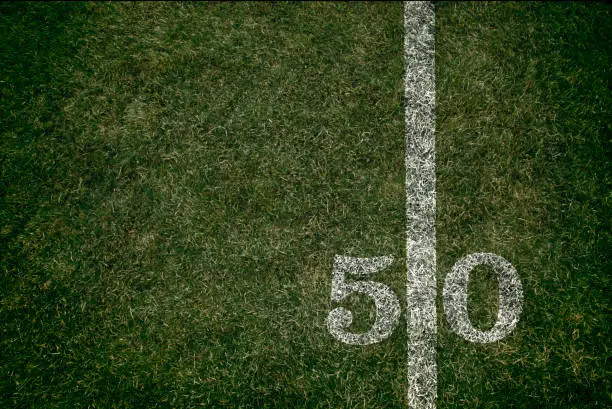 American Football field 50 yard score line. Team sports. Fifty yard line during Friday night lights.