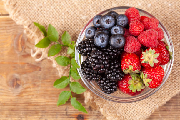 istock Fresh berries in a bowl on rustic wooden background. 1177749420
