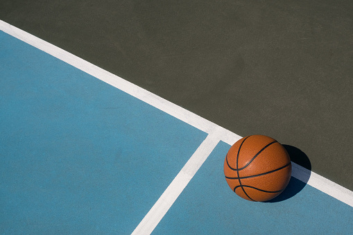 Leather basketball on colorful outdoor court - great background for your hoops related event