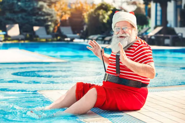 Photo of Santa Claus near the pool holiday vacation concept