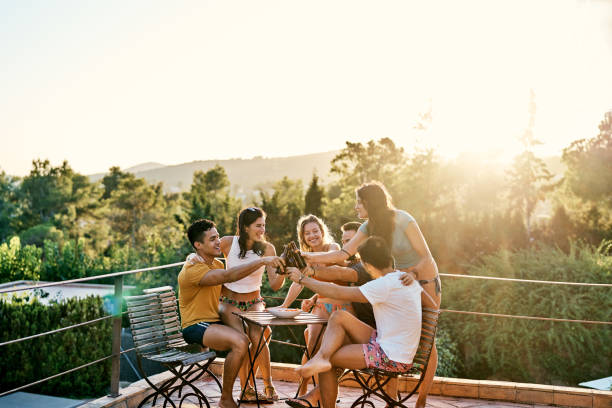 istock Smiling friends enjoying toasting beer bottles 1177752092