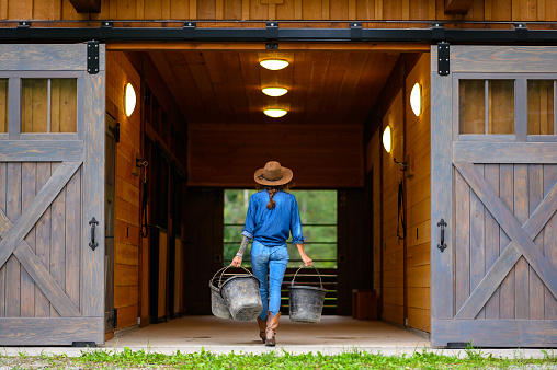 Female farmer working around her barn. Rancher working on a Canadian ranch. Empowered woman working in agriculture.