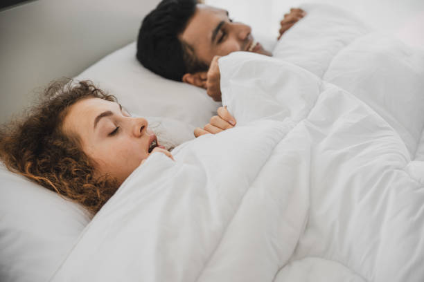 istock a man and a woman lying on a bed 1177764585