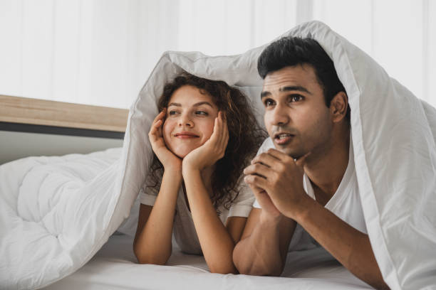 istock a man and a woman lying on a bed 1177764634