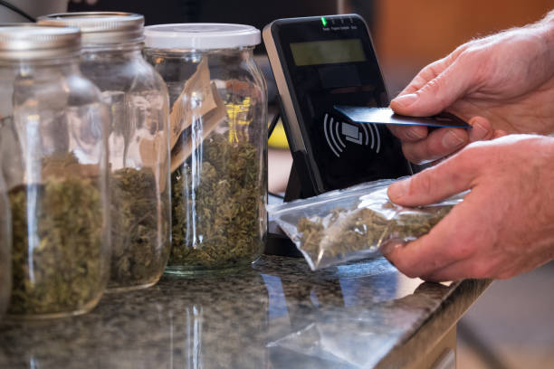 Purchasing legal marijuana at a dispensary Purchasing legal marijuana at a local dispensary using my card as a method of contactless payment. cannabis store photos stock pictures, royalty-free photos & images