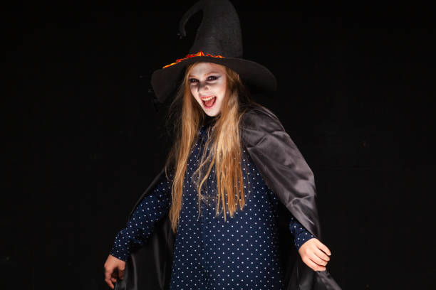 istock Halloween. Witch with a spider on his hat on black background. Beautiful young surprised woman in witches hat and costume holding. Wide Halloween party art design. Copy-paste. Witch craft concept. Close up 1177790872