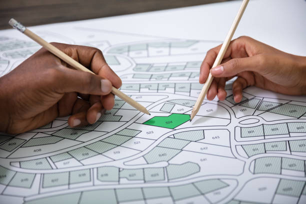 istock Hands Holding Pencils Over Cadastre Map 1177793578