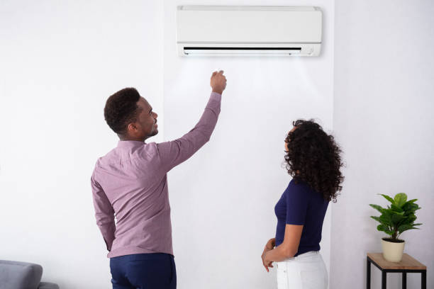 istock Couple Adjusting Temperature Of Air Conditioner 1177794883
