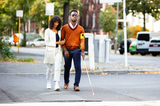 istock Woman Assisting Blind Man On Street 1177796470