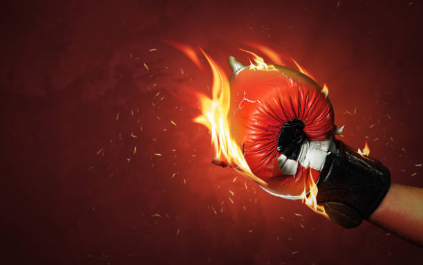istock Old red boxing gloves on hot sparkles background with extreme fire flame and fighting fiercely hand for winner or success concept. 1177797159