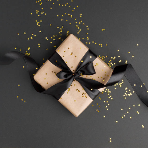 istock Gift or present box and gold stars confetti on black table top view. Flat lay composition for birthday, mother day, black friday sale, xmas, christmas, new yaer or wedding. 1177801032