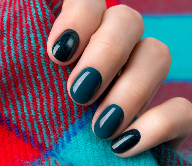 istock Woman's hands with turquoise glittering manicure holding warm wool fabric 1177802754