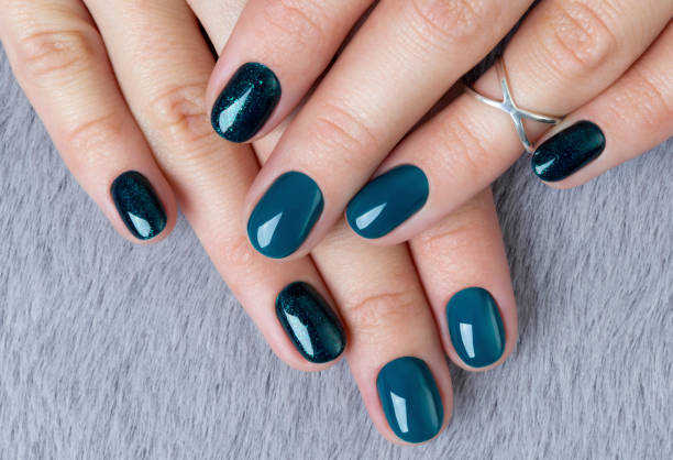 istock Woman's hands with turquoise manicure and ring on grey furry background 1177802764