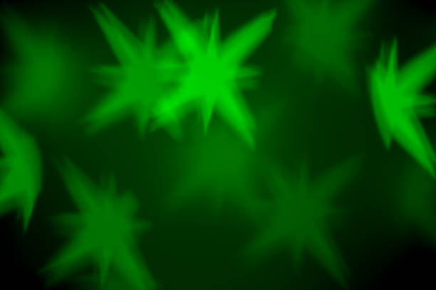 Green Christmas background - defocused bokeh with star shape. Space for copy. It's a real bokeh photo, not an illustration or computer effect.