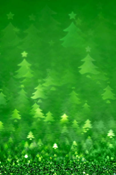 Green Christmas background - defocused bokeh with Christmas tree shape. Space for copy. It's a real bokeh photo, not an illustration or computer effect.