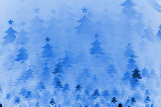 Blue Christmas background - defocused bokeh with Christmas tree shape. Space for copy. It's a real bokeh photo  (negative), not an illustration or computer filter.