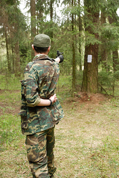 homme avec une arme à feu - back lite photos et images de collection