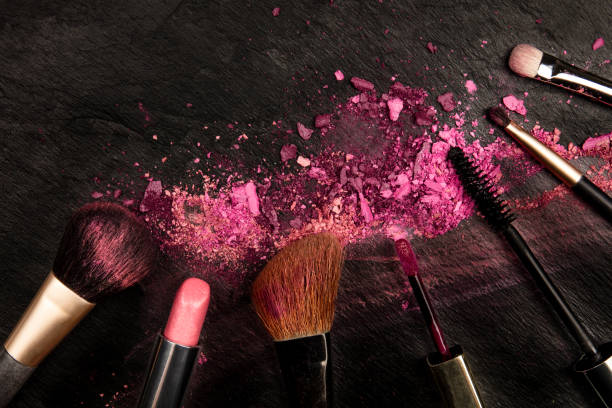 istock Make-up brushes and lipstick with crushed cosmetics, overhead shot on a black background with copy space, a beauty design template for a makeup banner 1177814466