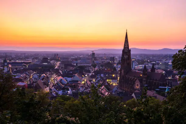 Photo of Germany, Magical sunset red sky over city freiburg im breisgau and famous minster church aerial view in summer