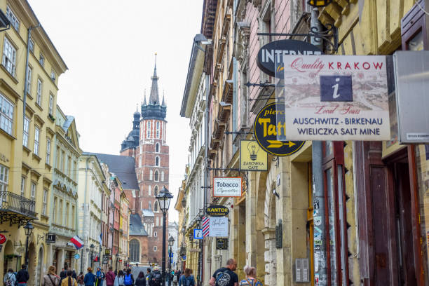 touristes à la rue de florianska avec l'église de basilique de rue mary à l'arrière-plan, la rue la plus célèbre de cracovie, pologne - florianska street photos et images de collection