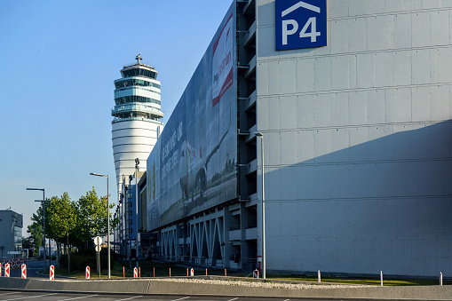 Schwechat, Austria - May 08, 2019: Main tower of Vienna international airport with parking building on the right side with Austrian airlines (which has main base at Vienna) banner on wall