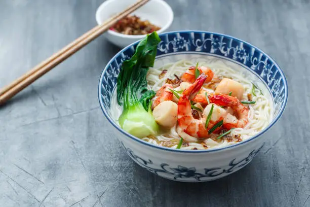 Rice noodle soup with seafood and chicken broth, copy space.