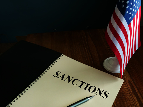 Sanciones americanas y bandera de EE.UU. en la mesa. photo