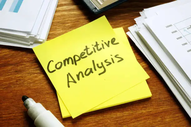 Photo of Competitive Analysis report and stack of business papers.