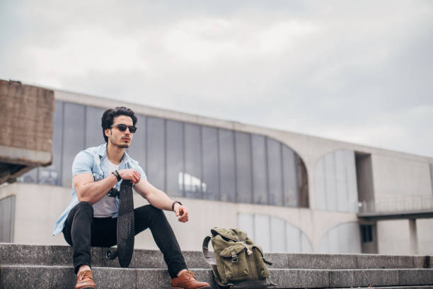 istock Handsome skateboarder sitting on stairs 1177824264