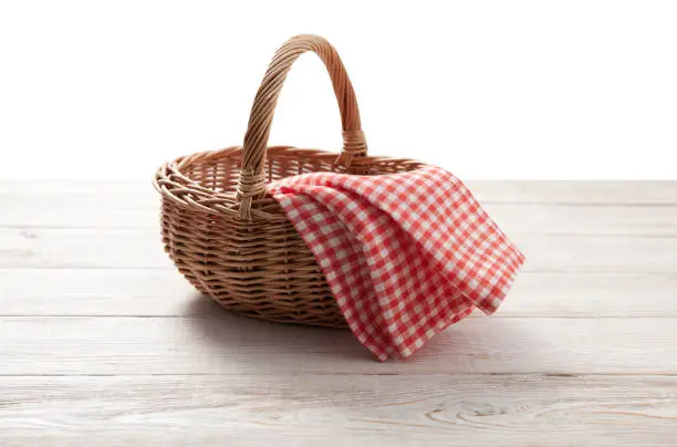 Photo of red napkin picnic basket and wood table place