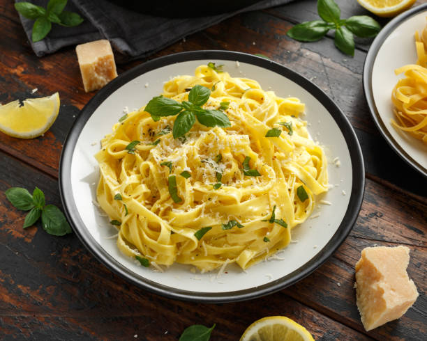 istock Pasta al Limone, Lemon with basil and parmesan cheese on wooden table 1177829283