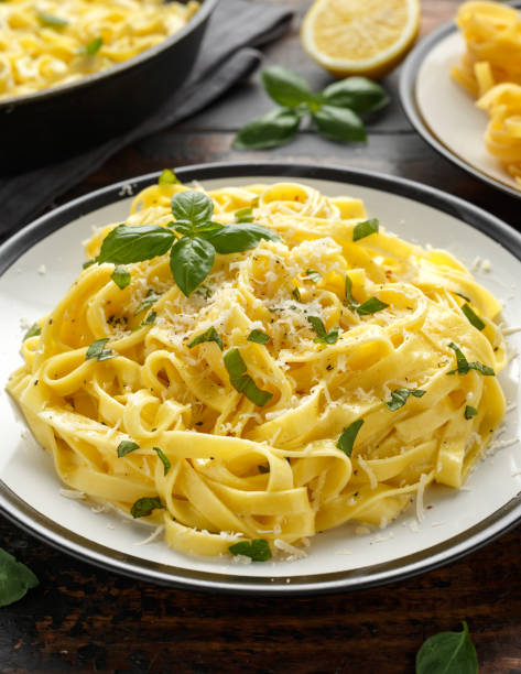 istock Pasta al Limone, Lemon with basil and parmesan cheese on wooden table 1177829362
