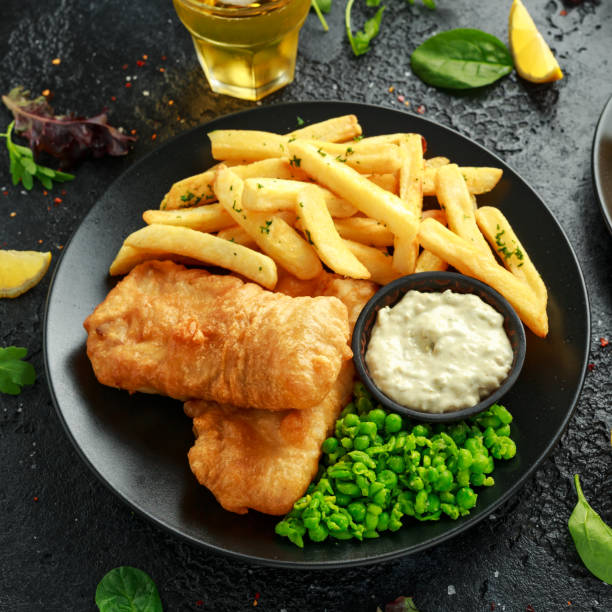 istock British Traditional Fish and chips with mashed peas, tartar sauce and cold beer. 1177829409