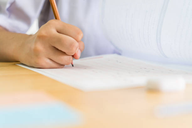 istock hand student testing in exercise taking fill in exam carbon paper answer sheet with pencil at school or university in test room, document exams at campus classroom, education or back to school concept 1177834533